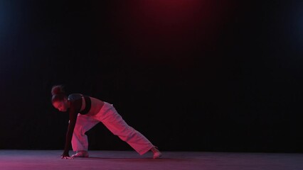 Woman's Dance Performance Amidst Red Lighting And Dark Backdrop