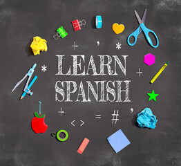 Learn Spanish theme with school supplies on a chalkboard - flat lay