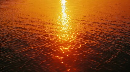 The sun is dipping below the horizon, casting a warm glow over the rippling surface of the water. The sky is ablaze with hues of orange, pink, and purple as the day draws to a close.