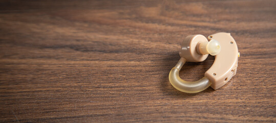 Hearing aid on the wooden table.