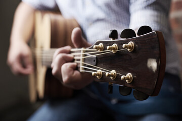 Hands, home and man with guitar, music and instrument with strings, talent and musician. Learning,...