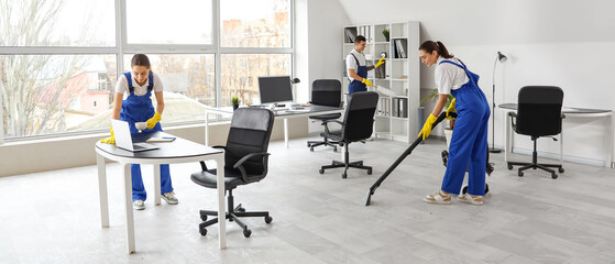 Young janitors cleaning in office