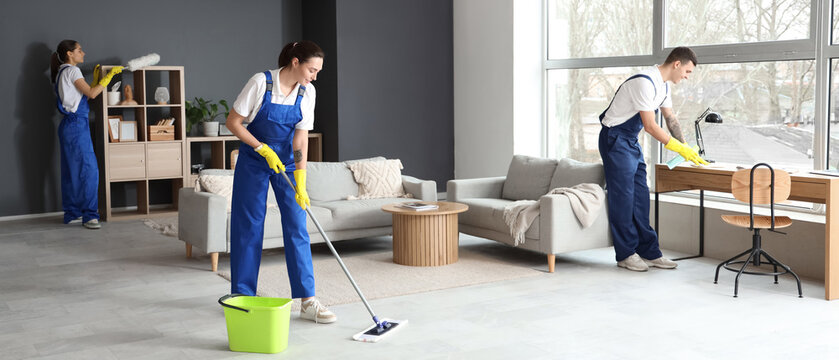 Young janitors cleaning in room