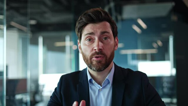 First person view of brunette male in jacket making video call with remote business partners on blurred background. Millennial person discussing strategy on distance while using wireless connection.