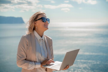 Freelance women sea. She is working on the computer. Good looking middle aged woman typing on a...