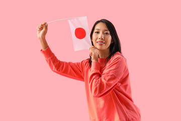 Young Asian woman with flag of Japan on pink background