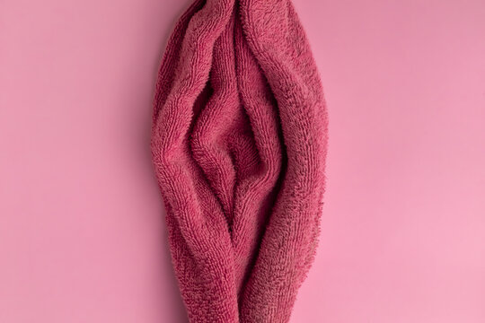 red towel fabric shaped as woman vagina on the pink background