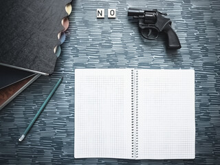 No guns message wood letters school supplies and gun on table copy space