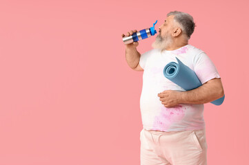 Overweight mature man with yoga mat and bottle of water on pink background. Weight loss concept