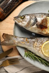 Delicious baked fish served on table, top view