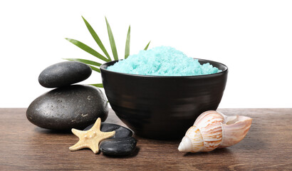 Light blue sea salt in bowl, spa stones, starfish, seashell and palm leaf on wooden table against...