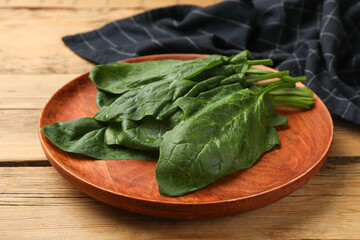 Wet fresh spinach leaves on wooden table, closeup