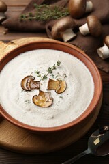 Fresh homemade mushroom soup in ceramic bowl on wooden table