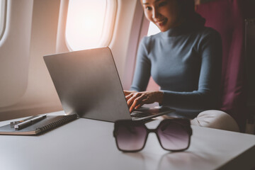 Airplane passengers, business people use laptops on the plane to work while sitting on the plane....