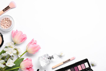Flat lay composition with different makeup products and beautiful spring flowers on white...