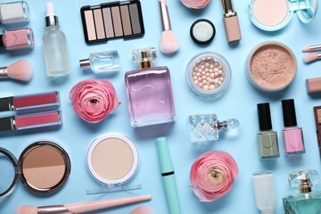 Obraz na płótnie Canvas Flat lay composition with different makeup products and beautiful spring flowers on light blue background