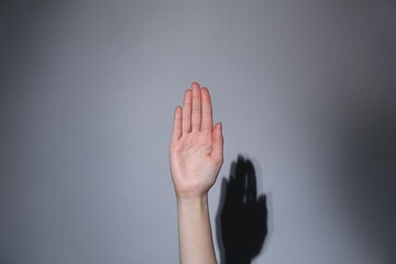 Woman showing open palm on grey background, closeup