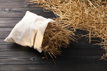 Dried straw in burlap sack on dark wooden table