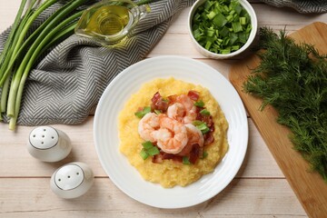 Plate with fresh tasty shrimps, bacon, grits and green onion on light wooden table, flat lay