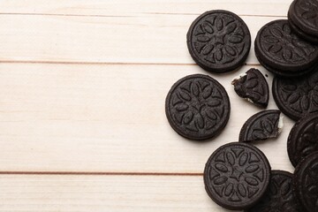 Tasty sandwich cookies on light wooden table, flat lay. Space for text