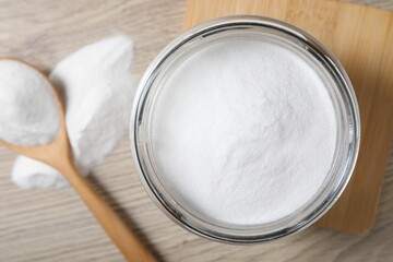 Baking soda in glass jar on wooden table, top view