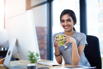 Coffee, computer and portrait of creative Indian woman in office with confidence, relax and smile...