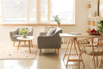 Interior of stylish living room with sofa, coffee table, carpet and window