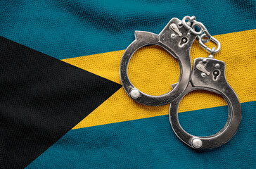 Flag of Bahamas and police handcuffs. Crime and offenses in country Concept
