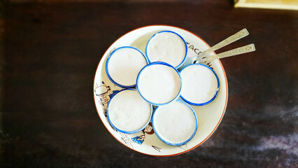 Food dessert concept Thai dessert Kanom Tuay is Thai coconut pudding with a creamy coconut cream atop on black background. Steamed coconut milk, Thai coconut rice custard.