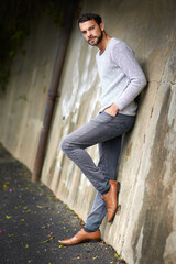 Fashion, portrait and serious with man on wall of urban town for trendy style in casual outfit....