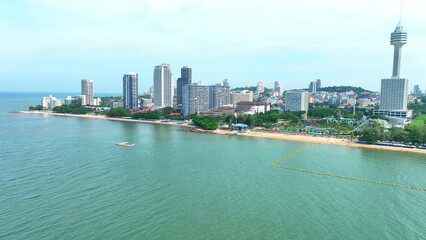 Naklejka premium Jomtien Beach, an oasis of calm amidst the bustling Pattaya. Soft waves, swaying palms, and a laid-back atmosphere invite you to unwind and escape the city's hustle. Thailand. Aerial view drone. 
