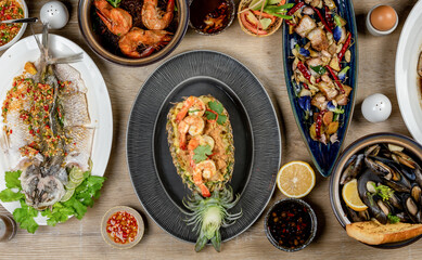 A table full of delicious food, including seafood, meat, and vegetables.