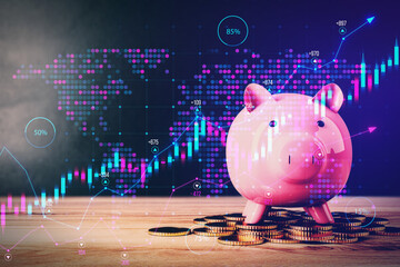 Close up of pink piggy bank on wooden surface with map and growing forex chart on blurry...
