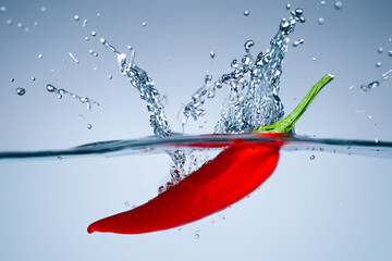 pepper in water. red hot pepper floating in water with splashes, creative concept