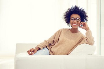 Sofa, happy and portrait of black woman in home for relaxing, chill and free time on weekend. Apartment, house and person smile in living room with happiness, joy and confidence in morning sunshine