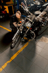 In a motorcycle repair shop master repairs a motorbike and updates fuel supply systems