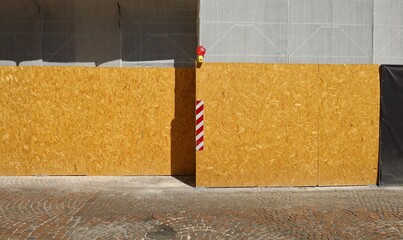 Red and white diagonal stripes warning sign on oriented stranded board fence.Red warning light and...