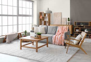 Modern interior of living room with cozy sofa, armchair and coffee table
