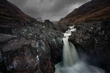 Waterfall in Glen Etive with dramatic scenery. Located in Glen Etive, Highlands, Scotland.