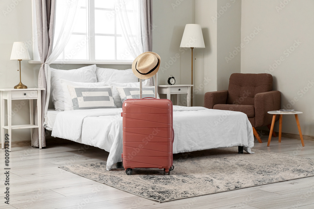 Sticker Suitcase with hat in interior of light hotel room