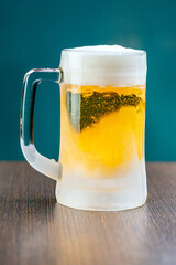 A frosted mug of beer on a wooden table.