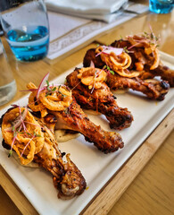 Tandoori chicken leg pieces arranged in a white plate. Selective focus