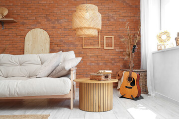 Interior of beautiful living room with comfortable sofa, guitar and coffee table