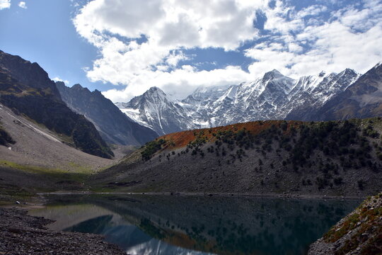 Marvelous landscape consisting of a lake and mountains with legendary Nanga parbat in background and clouds in the blue sky.