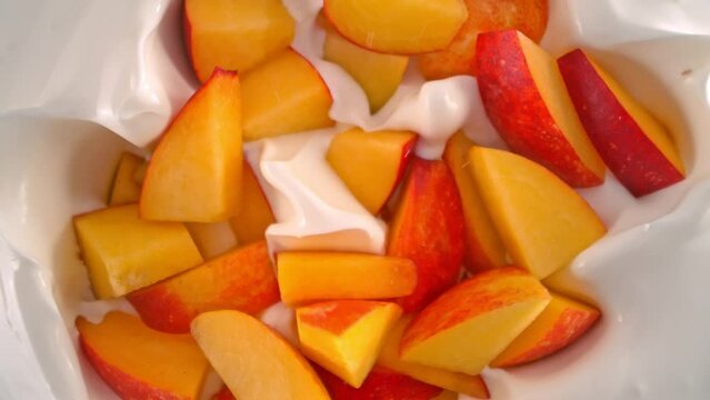 Super Slow Motion Shot of Peach Cuts Followed by Camera Falling into Yogurt at 1000fps.