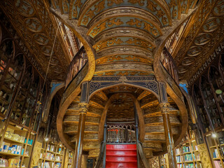 Naklejka premium PORTO, PORTUGAL - APRIL 21 2024 Interior view of Lello bookstore in Portuguese with its wooden staircase famous for Harry Potter film