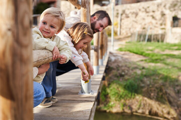 Happy young family in looking down in a bridge