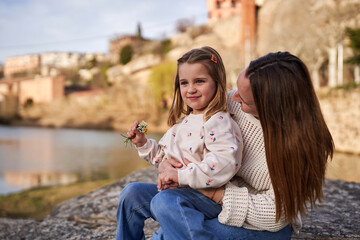Mother and daughter sharing good moments next to the river