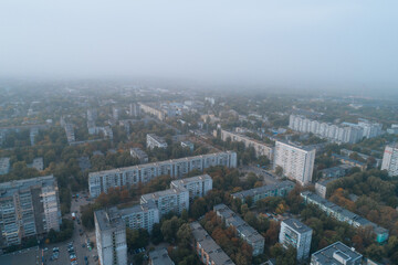 Fototapeta premium Aerial view of Dnipto city, Ukraine in fog. Cityscape. Panoramic view. Foggy metropolis. Ghost town. Atmospheric shot.