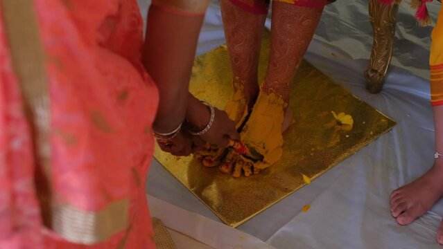Applying Haldi Turmeric Paste On Bride's Feet During Hindu Ceremony - Close Up